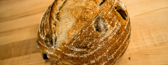 side photo of Kalamata olive bread has thin scrapes flecked by olives in crust